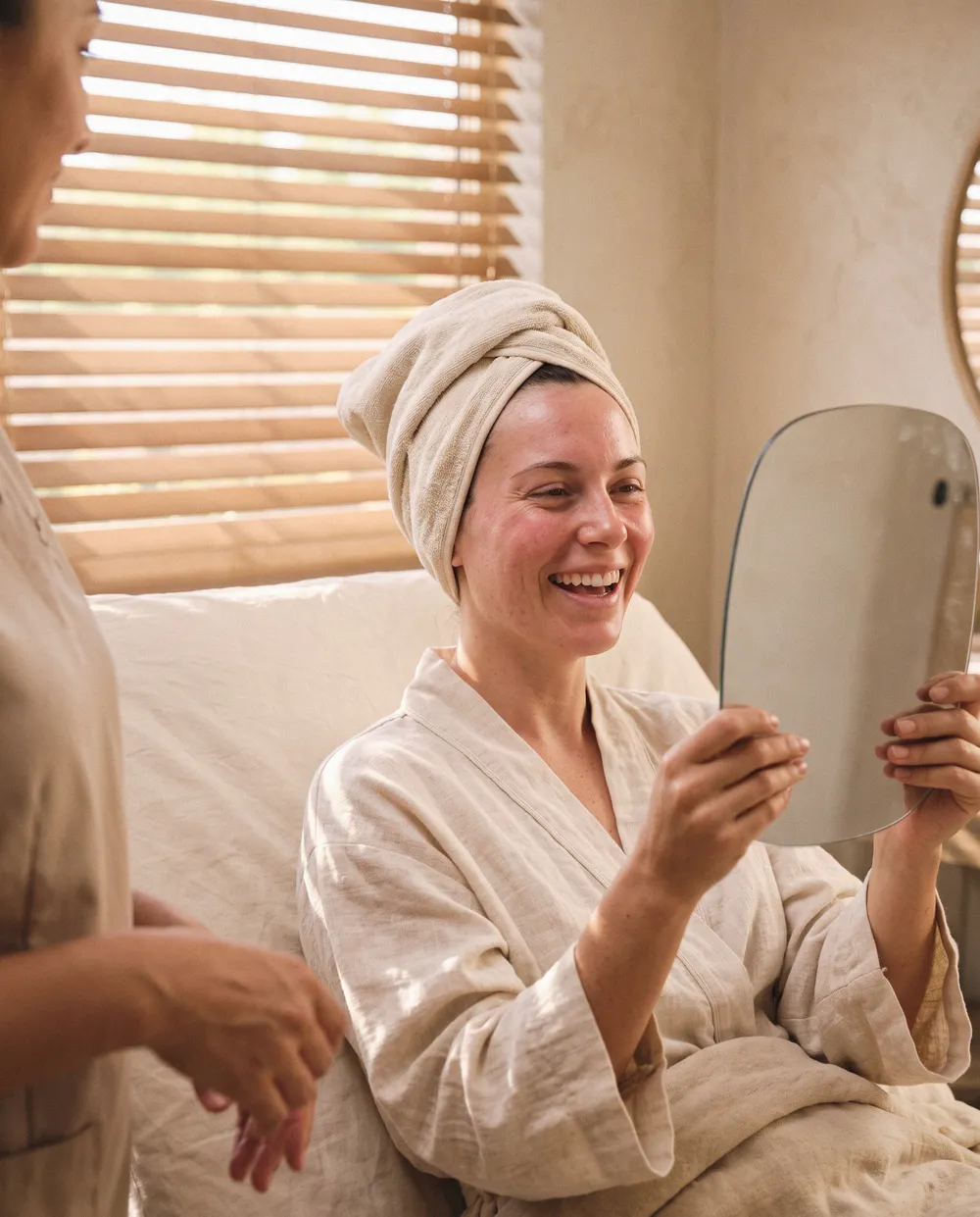A client laughing at her pink, dewy skin straight after microneedling